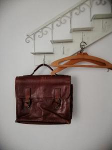un sac en cuir brun sur un portant dans un placard dans l'établissement Large apartment 800m from the beach 90 Square meters, à Ostende