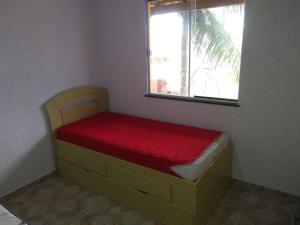 a small bedroom with a bed with a window at Casa de Praia / Cabo Frio in Tamoios
