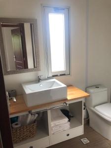 Un baño con lavabo, espejo e inodoro. en La Bruna, en Balneario Buenos Aires 16 fotos más