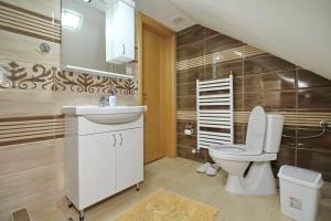 Un baño con un inodoro blanco y un lavabo. en Zlatibor Apartments NIKS, en Zlatibor