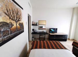 1 dormitorio con 1 cama y escritorio en una habitación en Coral Island Beach View Hotel, en Mazatlán