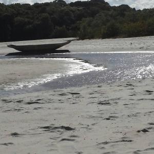 a boat sitting on the shore of a beach at Guaibim Residencial in Guaibim