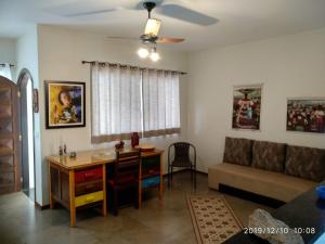 a living room with a desk and a couch at CASA 230 - Guest House in Piracicaba