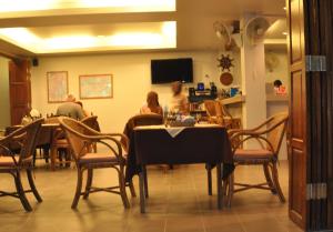 un groupe de personnes assises à une table dans un restaurant dans l'établissement Choophorn House SHA, à Kata Beach