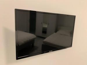 a mirror hanging on a wall next to a bed at Sleep2Fly Hamburg-Airport in Hamburg
