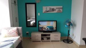 ein Wohnzimmer mit einem TV und einer blauen Wand in der Unterkunft Tenbury Apartments in Durban