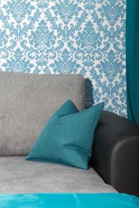 ein Sofa mit einem blauen Kissen im Wohnzimmer in der Unterkunft Rosenstein Apartments by Family & Home in Wien