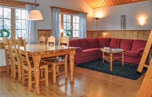 ein Wohnzimmer mit einem Tisch und einem roten Sofa in der Unterkunft Beautiful Home In Slen With House A Mountain View in Sälen