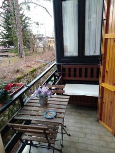 - une terrasse couverte avec un banc et une table fleurie dans l'établissement Casa Giovy, à Roccaraso