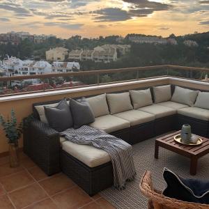 un divano su un balcone con vista sulla città di Luxurious duplex penthouse with golf and sea views a Benalmádena