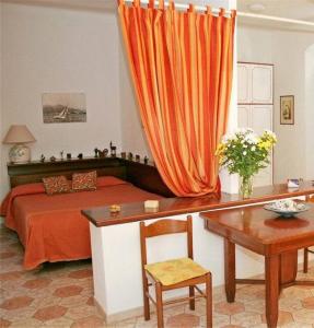 セストリ・レヴァンテにあるLa Casa delle Vitiのベッドルーム1室(オレンジ色のカーテン付きのベッド1台付)