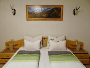 a bedroom with two beds and two antlers on the wall at Landhaus Rathgeb in Bad Gastein