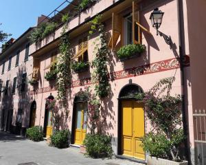 セストリ・レヴァンテにあるLa Casa delle Vitiの黄色の扉・花のピンクの建物