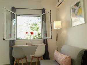 a room with a window with a table and two chairs at Cozy Studio 4U Gazi - Center Athens in Athens