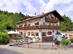 een groot wit gebouw met een balkon bij Gästehaus Alte Bergmühle in Fischbachau