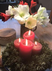 een groep kaarsen op een tafel met een vaas bloemen bij Gästehaus Alte Bergmühle in Fischbachau