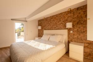 a bedroom with a bed and a brick wall at Villa Alzira in Seia