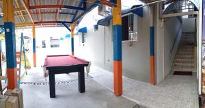 a pool table in the middle of a room with columns at Pousada Mares de Penha in Penha