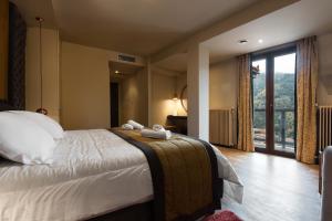 a bedroom with a large bed and a large window at Kentrikon Hotel in Lagadia