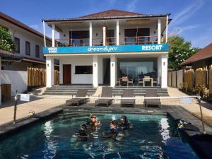 un grupo de personas en una piscina frente a una casa en Dream Divers Resort, en Gili Trawangan