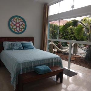 a bedroom with a bed and a large window at Pousada Gaucha Caiobá in Matinhos