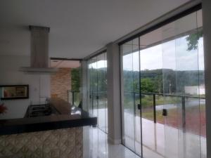 a kitchen with large glass doors and a balcony at Casa novanova in Capitólio