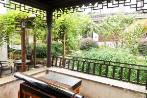 una bañera de hidromasaje al aire libre en un balcón con árboles en Pure-Land Villa, en Suzhou