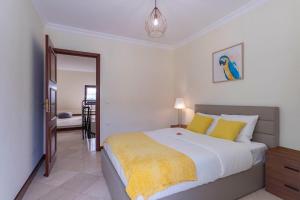 a bedroom with a large bed with yellow pillows at Heart of Ocean Dulpex Estoril in Estoril
