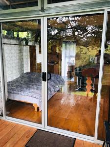 Cabaña treehouse Mountain View في San Isidro: غرفة بها أبواب زجاجية منزلقة مع سرير
