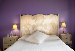 a bedroom with a large white bed with purple walls at La Casa de la Abuela Milagros in Pravia