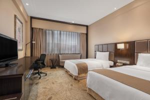 Holiday Inn Mudanjiang, an IHG Hotel في مودانجيانغ: غرفة فندقية بسريرين وتلفزيون بشاشة مسطحة