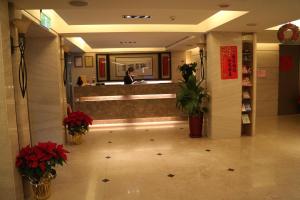 a lobby of a hotel with flowers and a counter at The Metro Hotel - Taipei Branch in Taipei