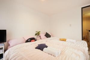 a bedroom with a large bed with stuffed animals on it at Kamiya TK Building 203 in Tokyo