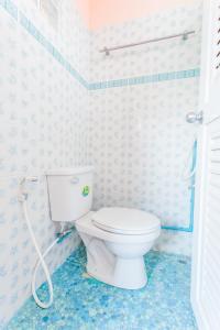 ein Bad mit einem weißen WC in einem Zimmer in der Unterkunft Gaiwandhanat Homestay in Bangkok