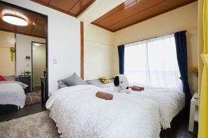 1 dormitorio con 2 camas y un osito de peluche. en Kamiya TK Building 301, en Tokio