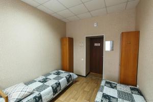 a bedroom with two beds and a door to a hallway at Gostinitsa on Martemyanova in Kemerovo