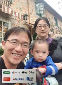 花蓮市的住宿－水悅雅築民宿 Shuiyue Guest House，一位男子和两名妇女带着婴儿摆出一张照片