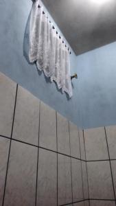 a bathroom with a white curtain hanging from a wall at Quarto familiar, aeroporto Guarulhos in Guarulhos