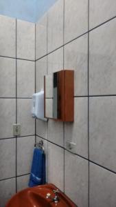 a bathroom with a sink and a soap dispenser on a wall at Quarto familiar, aeroporto Guarulhos in Guarulhos