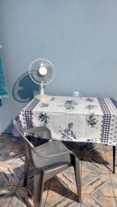 a table with a chair and a fan on it at Quarto familiar, aeroporto Guarulhos in Guarulhos