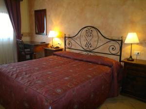 - une chambre avec un grand lit et un couvre-lit rouge dans l'établissement Villa Ambrosina, à Impruneta