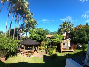 a backyard with a gazebo and palm trees at Les Agapanthes in Le Tampon