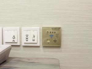 a remote control on a wall with four cards at Green Rose Hotel in Batam Center