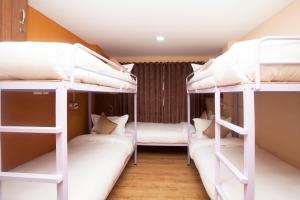 two bunk beds in a dorm room with white beds at Holiday Hostel in Kathmandu