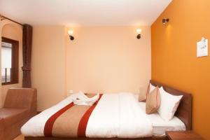 sypialnia z dużym łóżkiem z białą pościelą w obiekcie Holiday Hostel w Katmandu