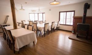 a dining room with tables and chairs and a fireplace at Annupuri Mountain View Lodge in Niseko