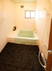 Annupuri Mountain View Lodge في نيسيكو: غرفة استحمام مع حوض في الحمام