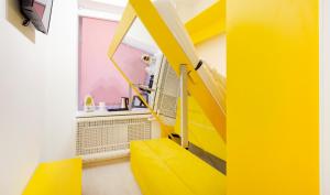 een gele trap in een kamer met een gele bank bij Smart Welcome by ACADEMIA in Sint-Petersburg