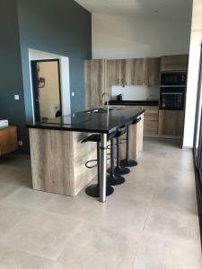 a kitchen with a black table and a sink at OCEAN SUNSET in Saint-Leu