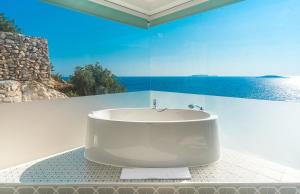 a bath tub in a bathroom with a view of the ocean at Mandalina Suites in Kaş